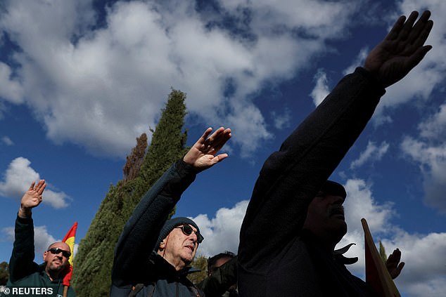People gesture the Roman salute on the 50th anniversary of the late Spanish dictator Francisco Franco's death, at an informal shrine, at the entrance to Franco's mausoleum in Madrid's Mingorrubio-El Pardo cemetery, Spain, November 20, 2025