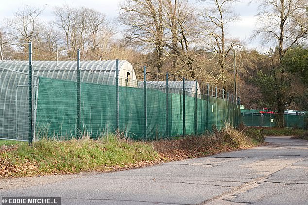 Plastic sheeting erected on a fence around the camp - which is near the quiet village of Crowborough