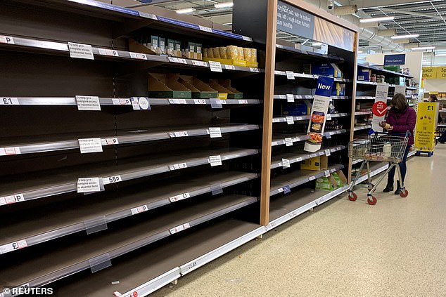 Shelves sit empty in a Tesco supermarket at the start of the pandemic, amid reports of Covid outbreaks in Manchester