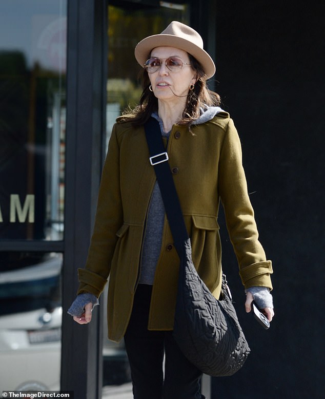 Hughes faced the autumn chill with a grey sweater featuring fingerless gloves