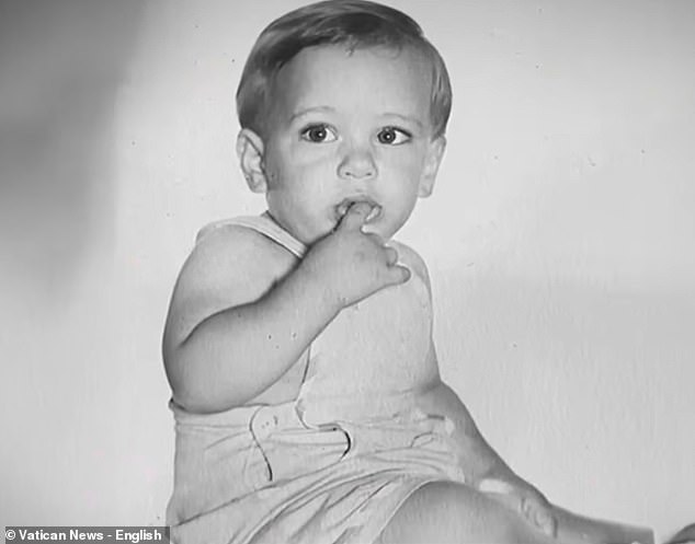 With his bright, wide eyes and and angelic grin, the toddler looks like any other child captured in the family photo album