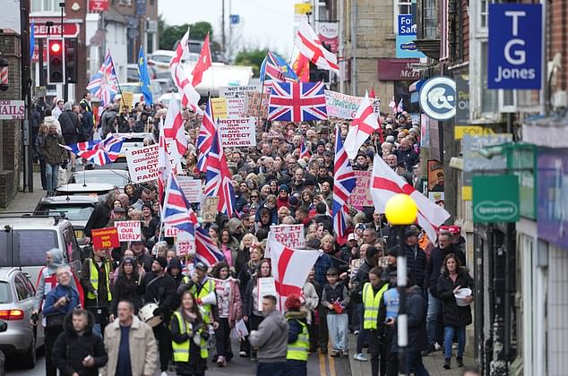 Crowborough, East Sussex: Protestors hold placards and march through the town centre over plans to house 600 male asylum seekers at Crowborough Training Camp. Pictured: Sunday, November 16