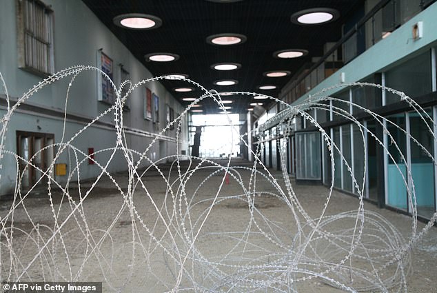Barbed wire prevents entry into the main hall inside the abandoned travel hub