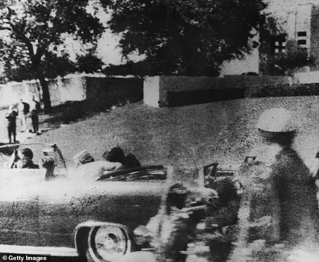 Kennedy's head slumps over after he is shot. Jackie Kennedy can be seen trying to help him