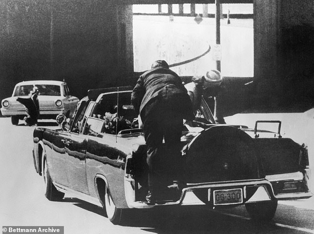 Secret Service Agent Clint Hill is seen jumping onto the presidential limousine to protect the president and the first lady. He later testify that Jackie Kennedy reached for bits of her husband's skull that were on lying on the trunk