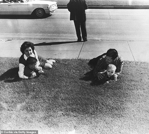 Another family is seen dropping to the ground after shots were fired at Dealey Plaza