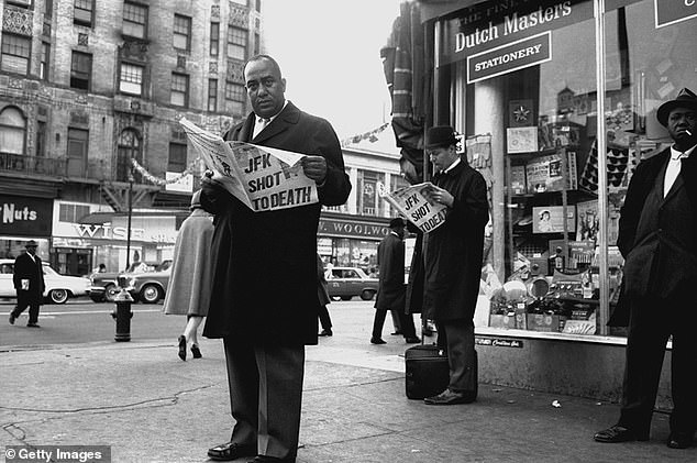 A man standing on the corner of 125th St. in Harlem reads the latest edition of the New York Post, which reported the news of the Kennedy's death