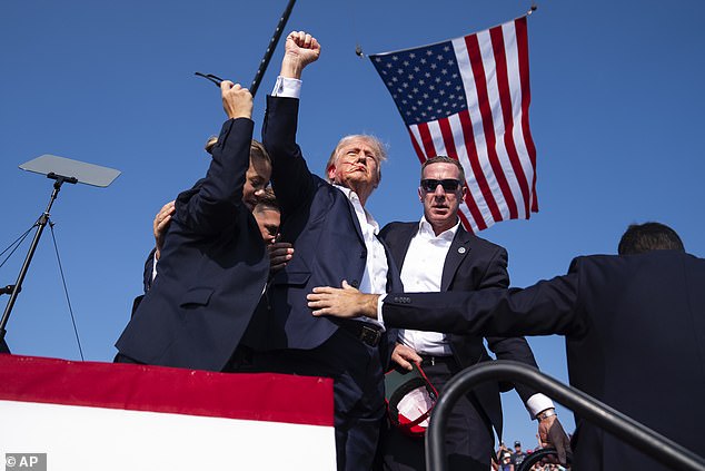 President Donald Trump is surrounded by U.S. Secret Service agents at a campaign rally on  Saturday, July 13, 2024, in Butler, Pennsylvania after surviving the assassination attempt