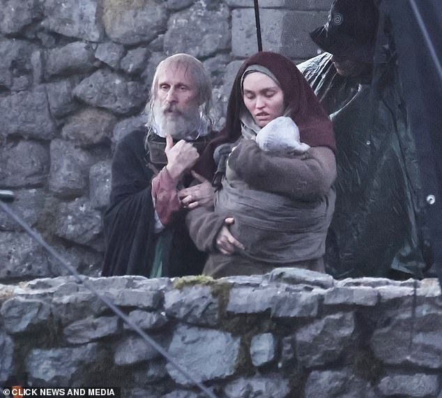 Lily-Rose holds a baby on set. She has been in a relationship with rapper 070 Shake, real name Danielle Balbuena, since early 2023