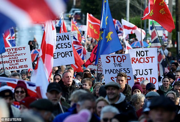 People attend a protest against asylum seekers being housed at an army training camp