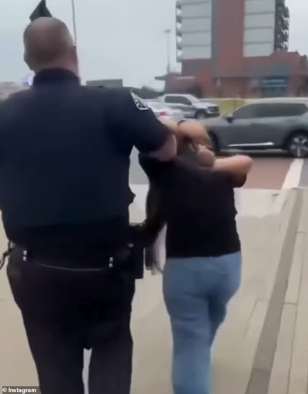 Ramos is seen being escorted from the scene after she was arrested on Friday