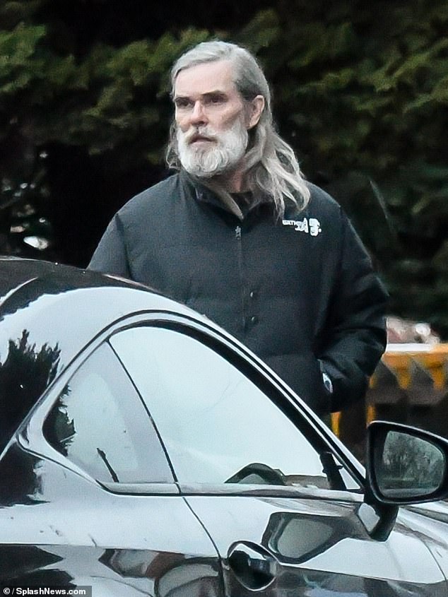 The Stone Roses frontman sported long grey hair and a bushy beard as he headed out in the rain