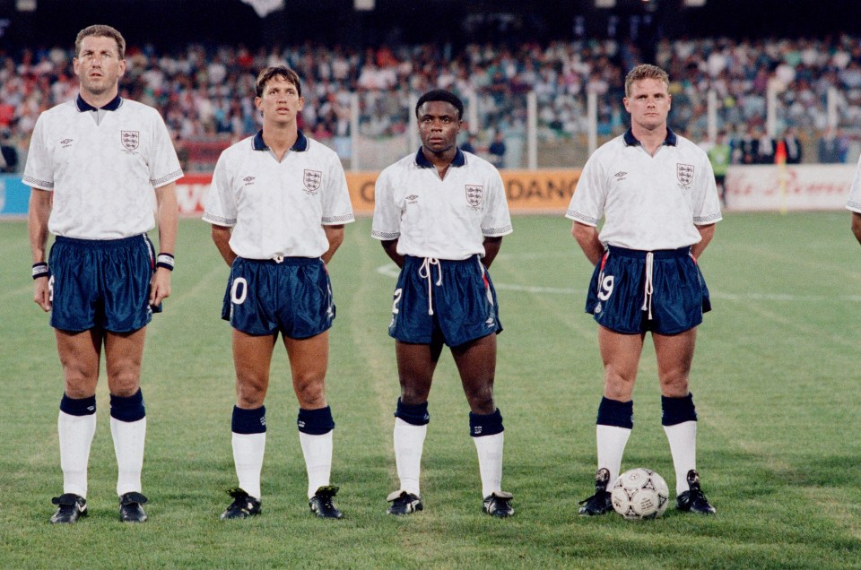 Four England National Soccer Team players, Terry Butcher, Gary Lineker, Paul Parker, and Paul Gascoigne, standing on a field during the 1990 FIFA World Cup.