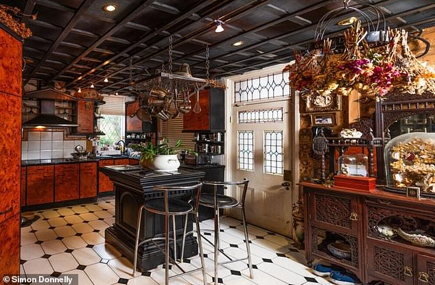 On entrance, the property showcases a bespoke breakfast kitchen appointed with rich, walnut-style cabinetry and a 'striking centre island' as a focal point