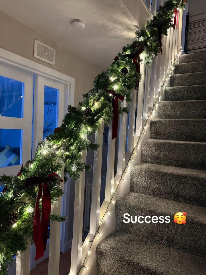 Staircase decorated with lighted garland for Christmas.