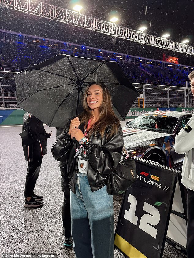 Flaunting her newly-dyed brunette locks, she also donned an effortlessly cool black leather jacket and jeans look as she posed beaming on the track, amid the pouring rain