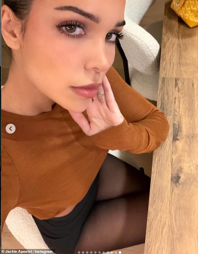 Jackie posed up a storm for the camera in one snap as she relaxed at home in a tan jumper and tiny shorts