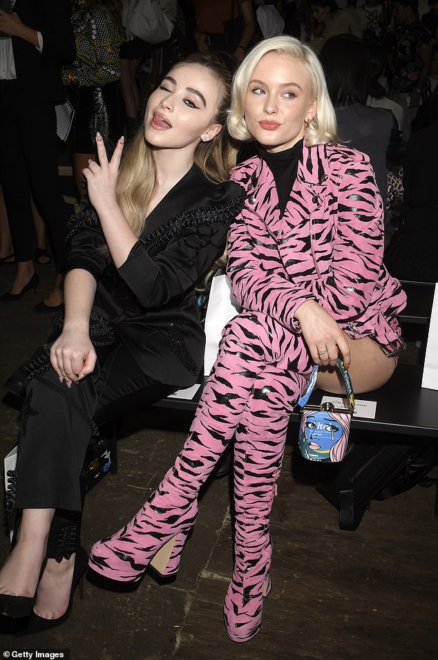 Sabrina (left) looks worlds away from her racy attires and diva platinum blow-dry and instead sports a more demure look in a black suit and stiletto heels