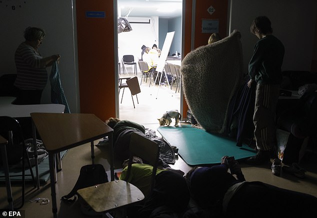 Ukrainians take shelter during an air-raid at the site of a Russian strike on a nine-storey residential building, in Kyiv, Ukraine, November 25, 2025