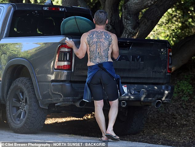 Meanwhile, his brother Josh was photographed surfing in Santa Barbara and sporting a huge tattoo on his back
