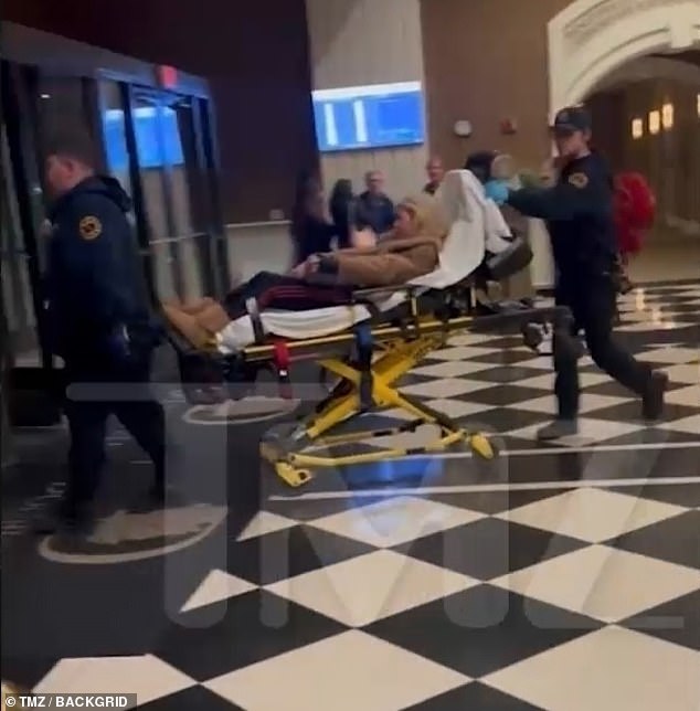 Reid is eventually helped back into the chair before paramedics load her onto a stretcher and take her away