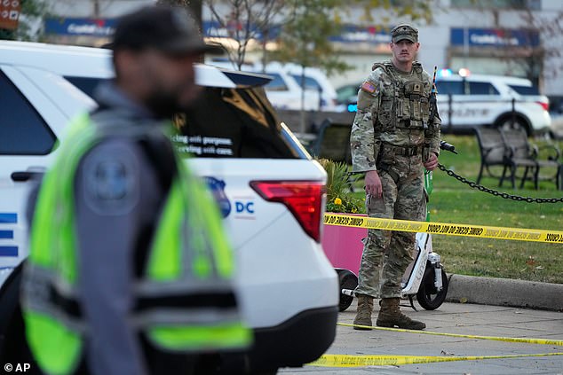 A National Guard soldier helps secure a perimeter in downtown DC near the White House following the shooting