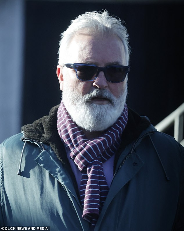 The handsome chap, 61, was seen walking down an Essex street wearing a purple shirt with a striped maroon scarf under a green coat