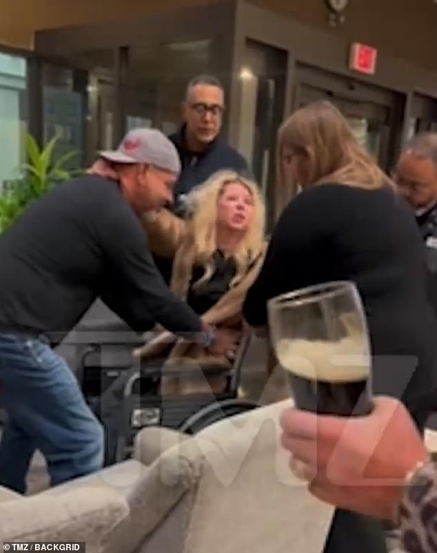 The video begins with Reid holding onto a man and speaking incoherently as she is placed in the wheelchair