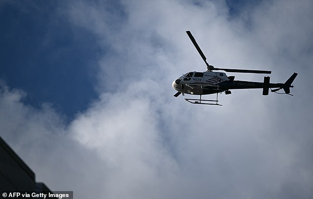 A police helicopter circles above the secured area after a shooting in downtown Washington, DC