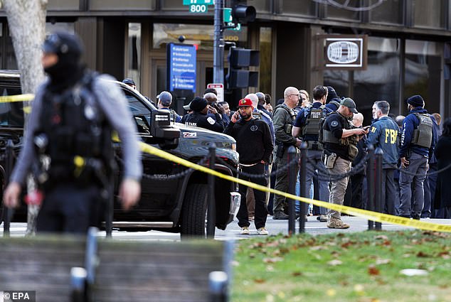 Law enforcement officers stand close to the scene where two West Virginia National Guard members were shot