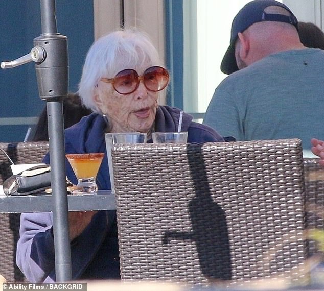 MacLaine sported a dark navy sweatshirt as well as a pair of fashionable shades as she sat at a table outside
