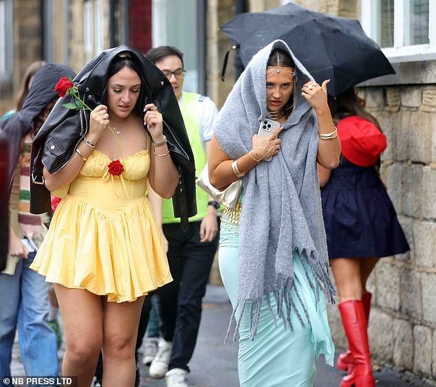 Pictured: Women sheltering themselves from the rain in Leeds brought over by Storm Claudia earlier this month