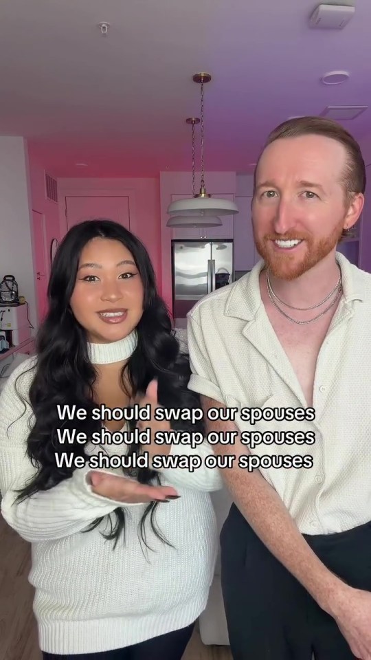 A smiling woman and a man in a video with the text "We should swap our spouses" repeated three times.