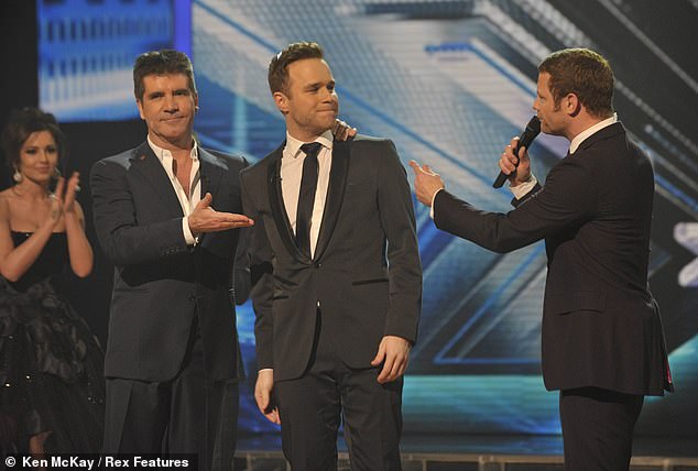 Olly Murs is consoled by Simon Cowell and host Dermot O'Leary after coming second place in 2009's The X Factor