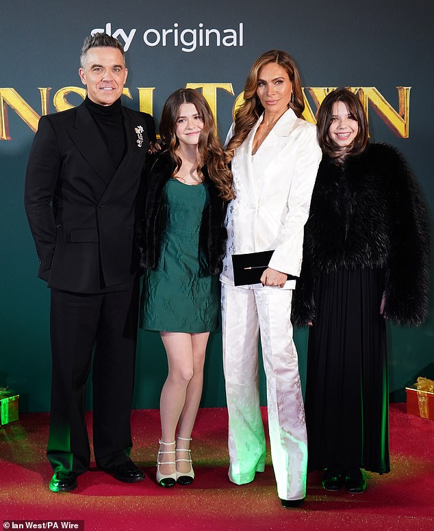 Proud parents Robbie and Ayda couldn't contain their smiles as they posed with their oldest child on the red carpet ahead of watching her first movie role; pictured with a friend