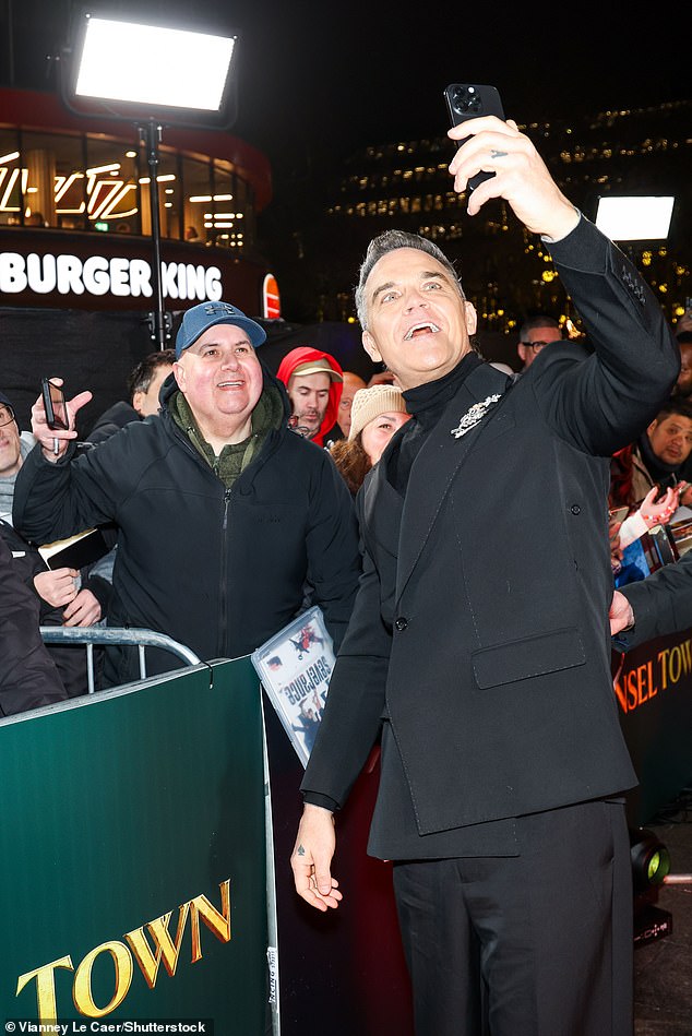 Robbie thrilled fans as he stopped to pose for selfies on arrival