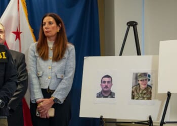 FBI Director Kash Patel looks at photographs of the two National Guard soldiers shot on Wednesday along with a photograph of their alleged assailant in Washington, DC on Nov. 27, 2025.