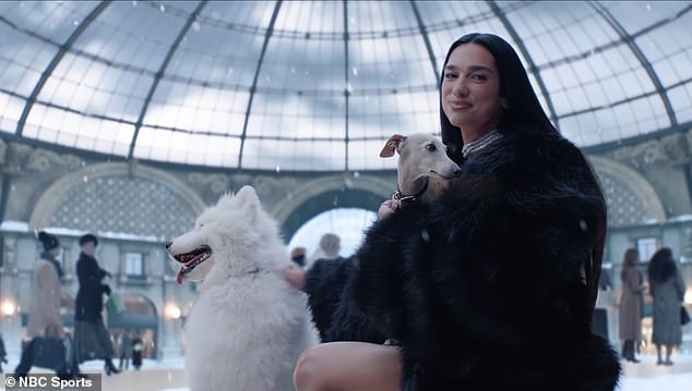 She appears to be in Milan's Galleria Vittorio Emanuele II wearing a silver dress and fur coat