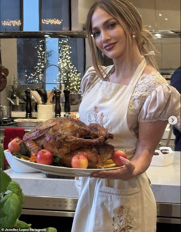 Lopez donned an apron over her silk beige dress to pose with the fully cooked turkey