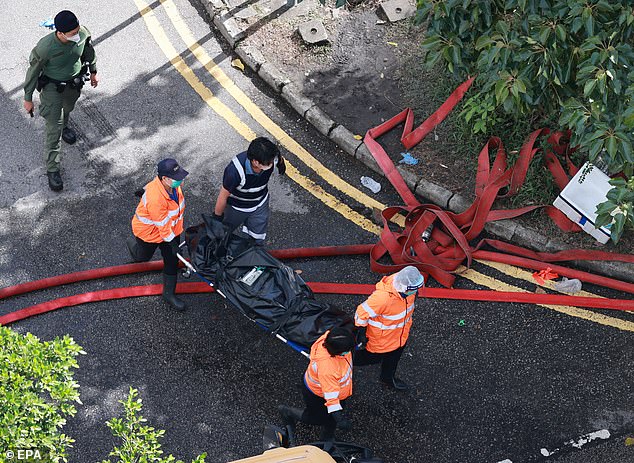Emergency responders carry a body at the scene of the Tai Po apartment fire in Hong Kong, China, 28 November 2025