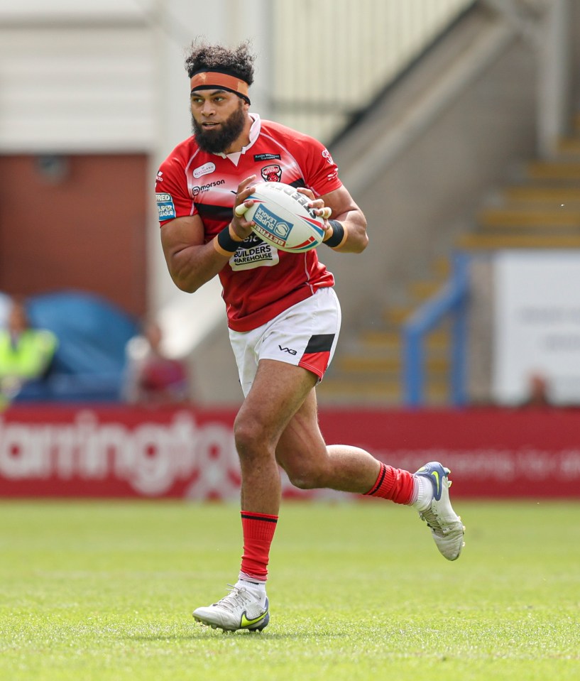 Sitaleki Akauola running with a rugby ball during a match.
