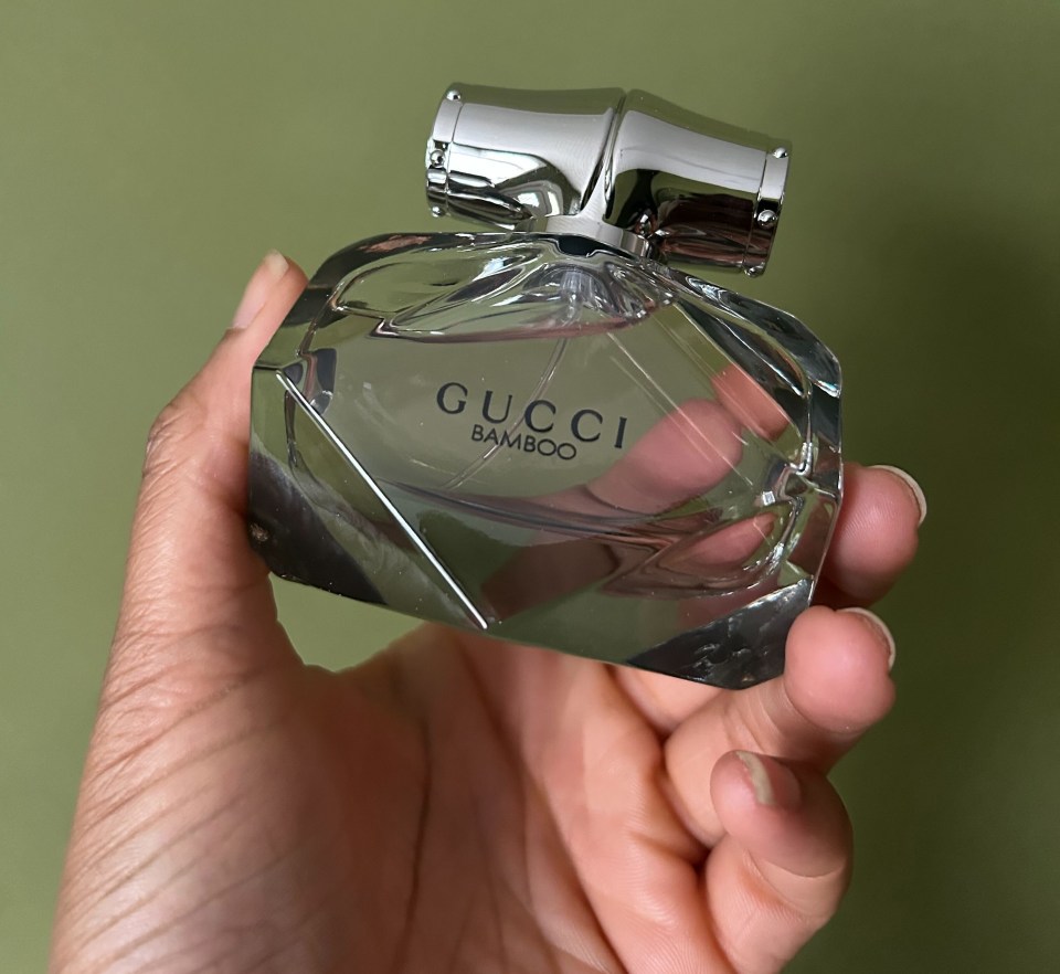 Hand holding a bottle of Gucci Bamboo perfume.