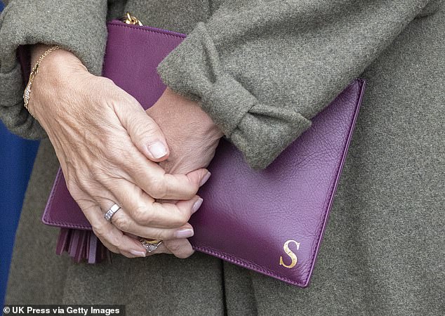 She could also be seen holding a personalised purple leather pouch bearing her initial