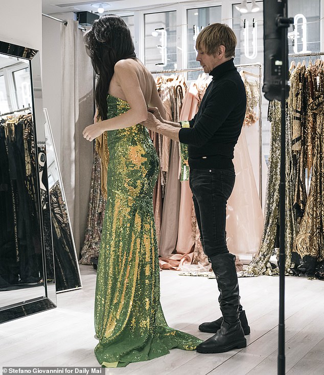 Bouwer is pictured in his studio with model Sabrina Perlleshi wearing one of his gowns