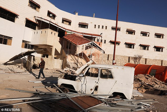 A vehicle sits amidst debris in front of Sednaya prison, December 17, 2024