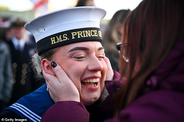 Sailors are greeted by family members after HMS Prince of Wales aircraft carrier arrives at Portsmouth Naval Base, on November 30, 2025 in Portsmouth, England