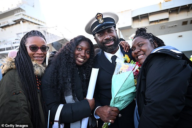 Sailors are greeted by family members after HMS Prince of Wales aircraft carrier arrives at Portsmouth Naval Base, on November 30, 2025 in Portsmouth, England