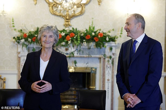 Ireland's President Catherine Connolly and Taoiseach Micheal Martin stand before presenting a seal of office to a new minister after a cabinet reshuffle, in Dublin, Ireland, November 18, 2025