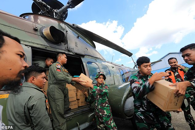 Indonesia National Armed Forces soldiers loads aid supplies to send to flood-hit areas