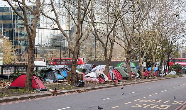 Tents and wooden pallets clutter the pavement next to the busy Euston Road in north London